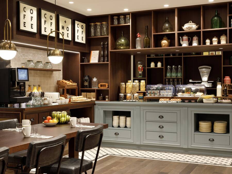 A modern kitchen with wooden cabinets, a dining table, and various kitchen appliances.