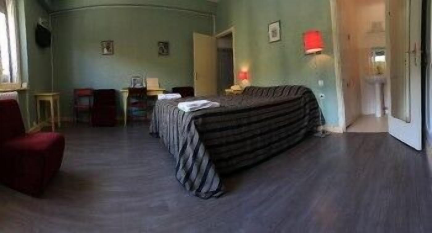 A room with a bed, a desk, a chair, and a lamp.