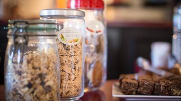 Tre barattoli di vetro con etichette su un tavolo, uno dei quali riporta la scritta 'Sans Gluten'.