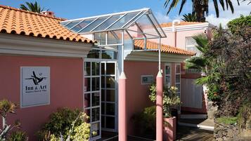 A building with a sign for 'Madera Hotel & Villas' and a covered entrance area with steps leading up to it.