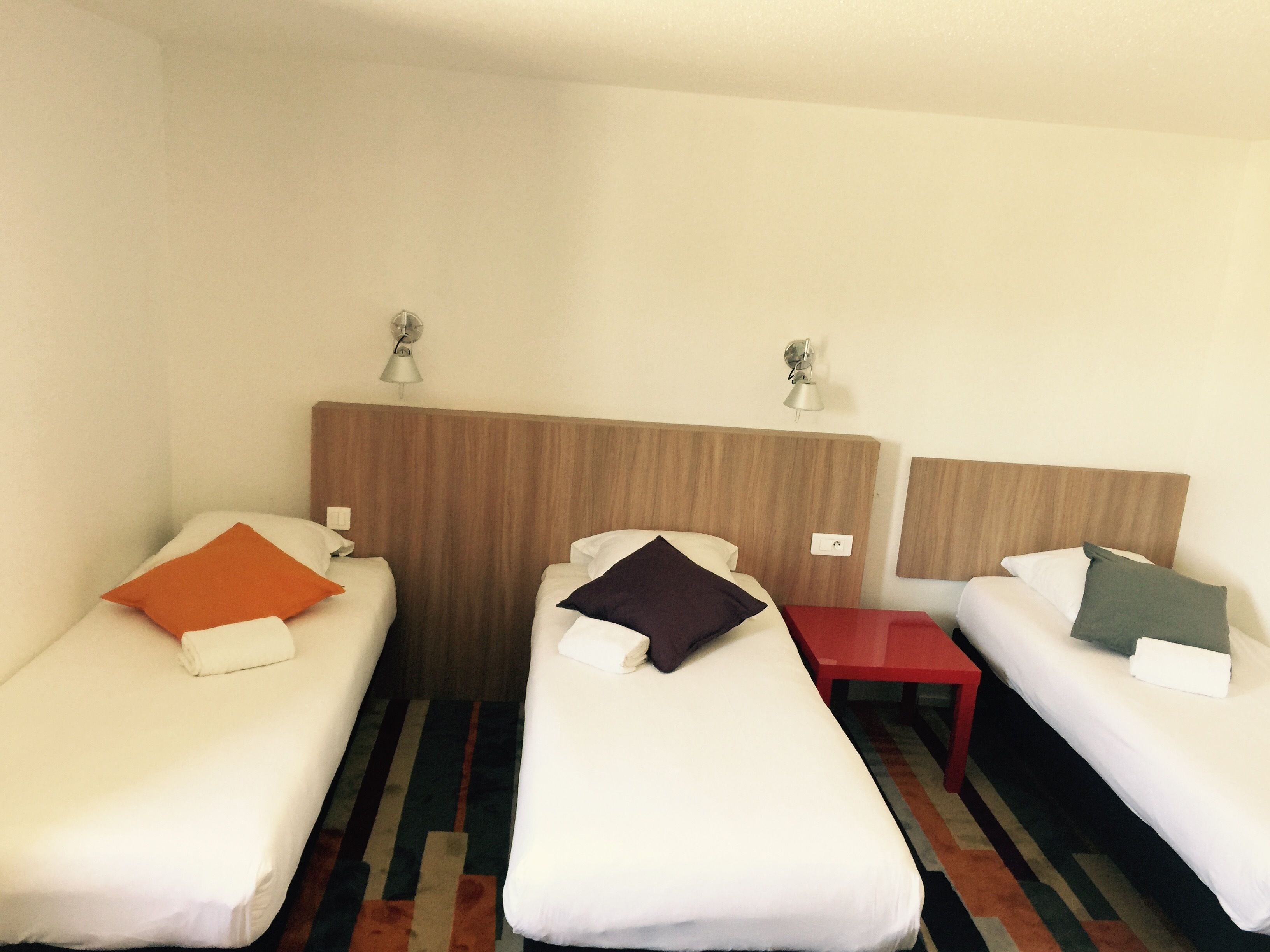 Una habitación de hotel con dos camas individuales, cada una con una almohada y una mesita de noche.