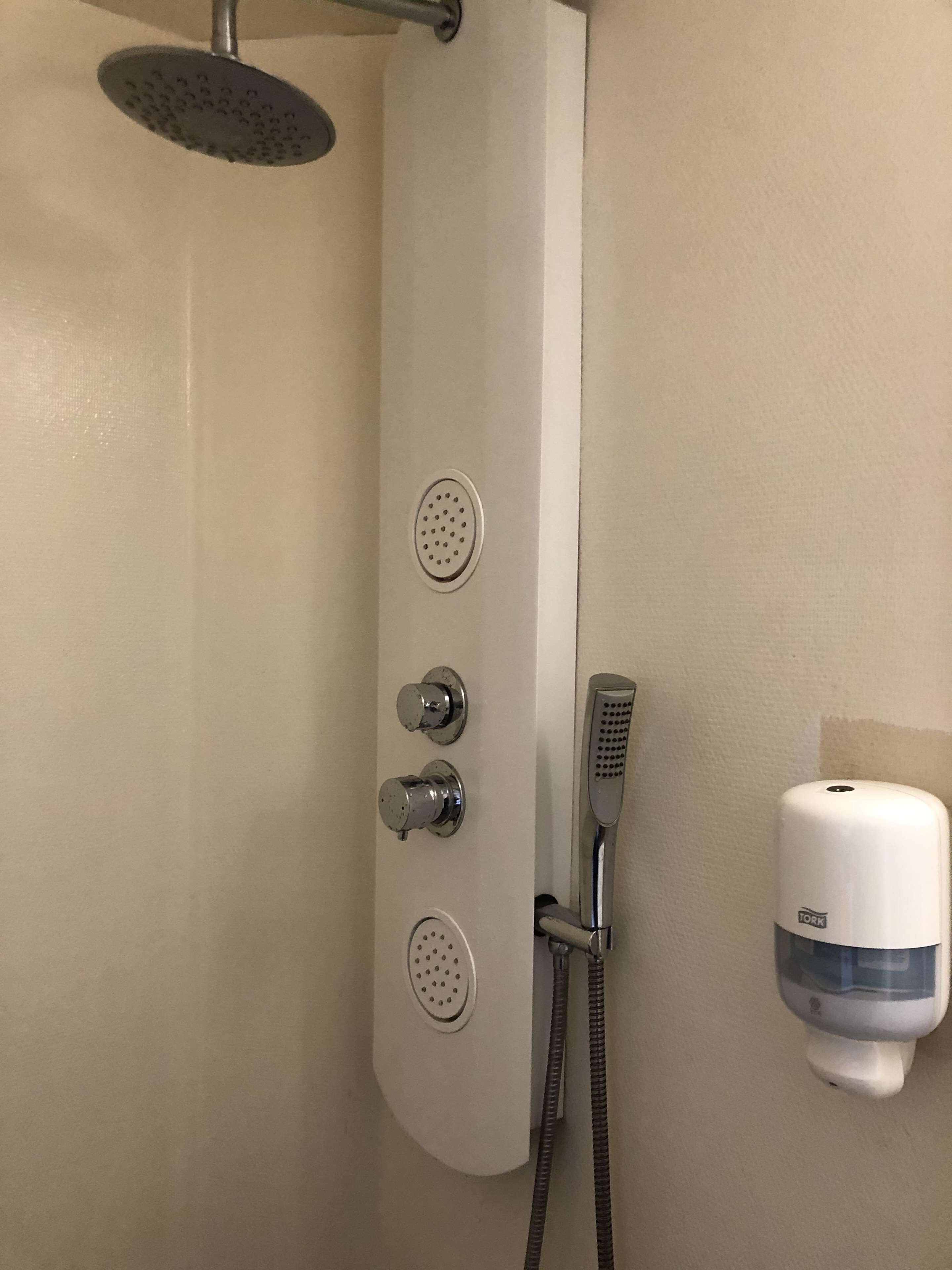 A shower with a handheld showerhead, a handheld shower nozzle, and a handheld shower attachment.