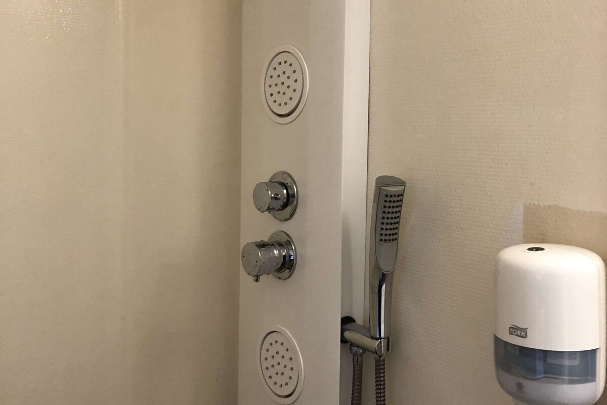 A shower with a handheld showerhead, a handheld shower nozzle, and a handheld shower attachment.