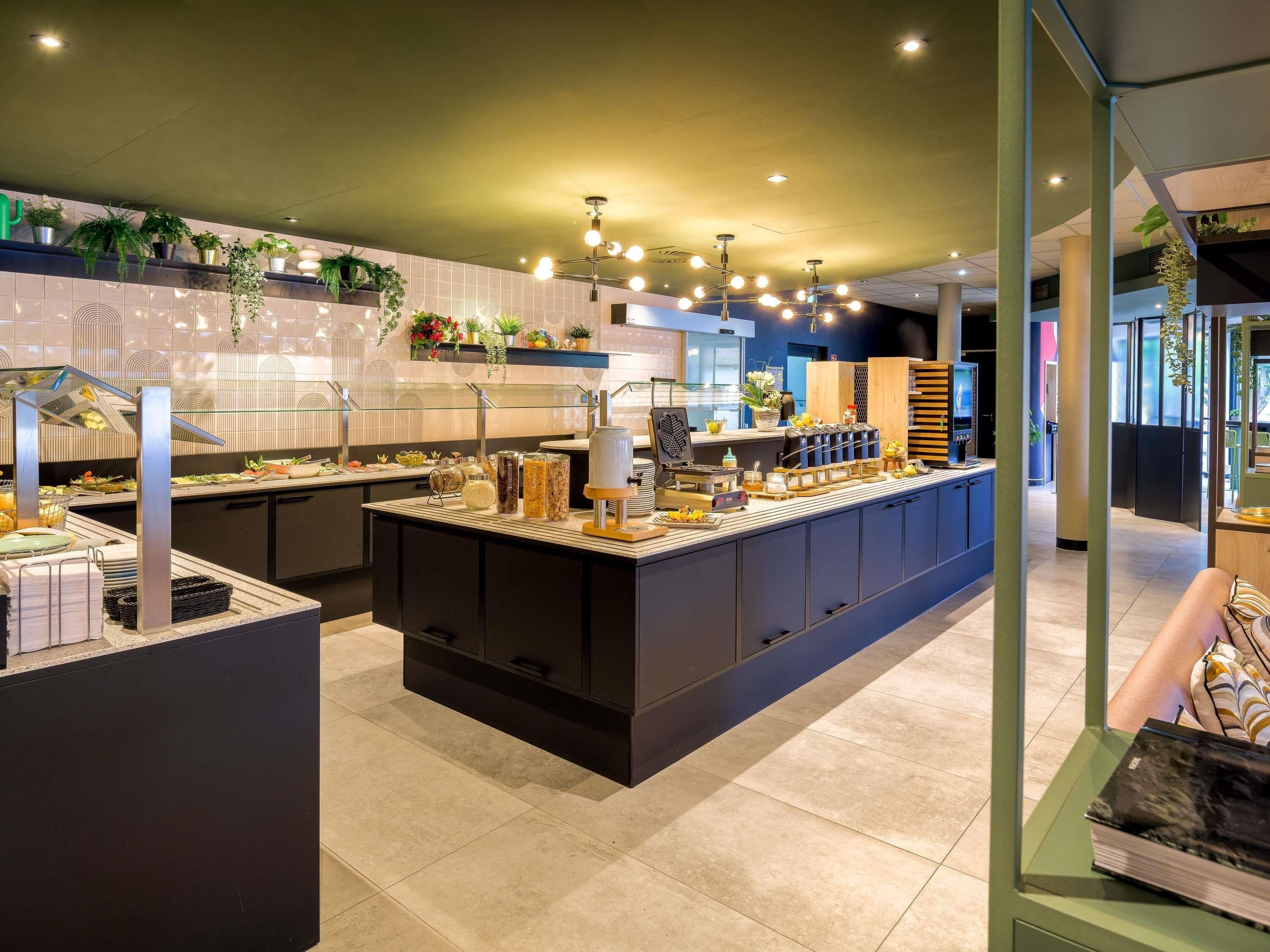 A modern kitchen area with a central island, various food items, and a glass display case.