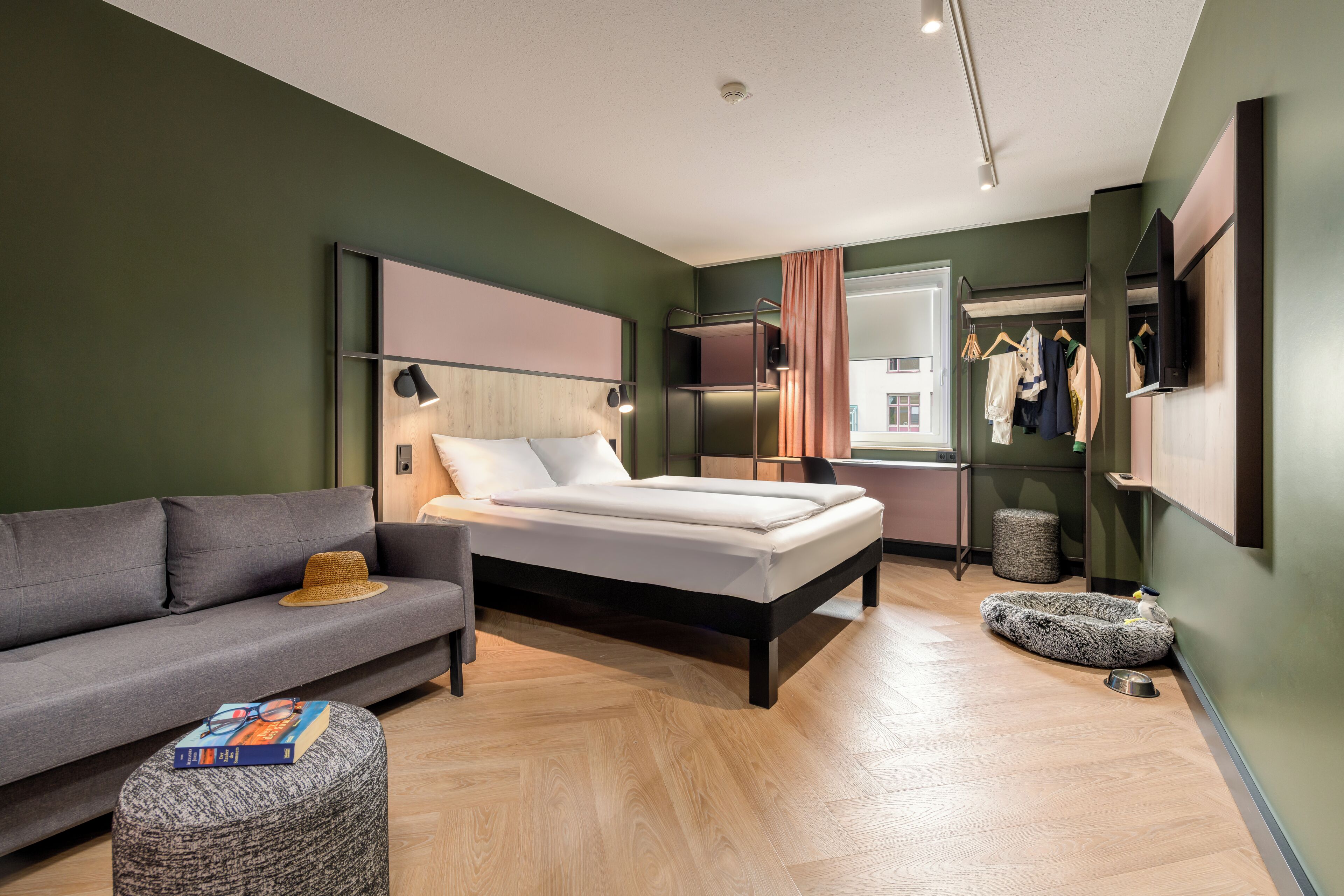 Een moderne slaapkamer met een bed, een bank, een kleine tafel en een kledingkast.