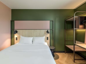 A hotel room with a bunk bed, a wooden headboard, two bedside lamps, and a round side table. - ibis Konstanz (Konstanz)