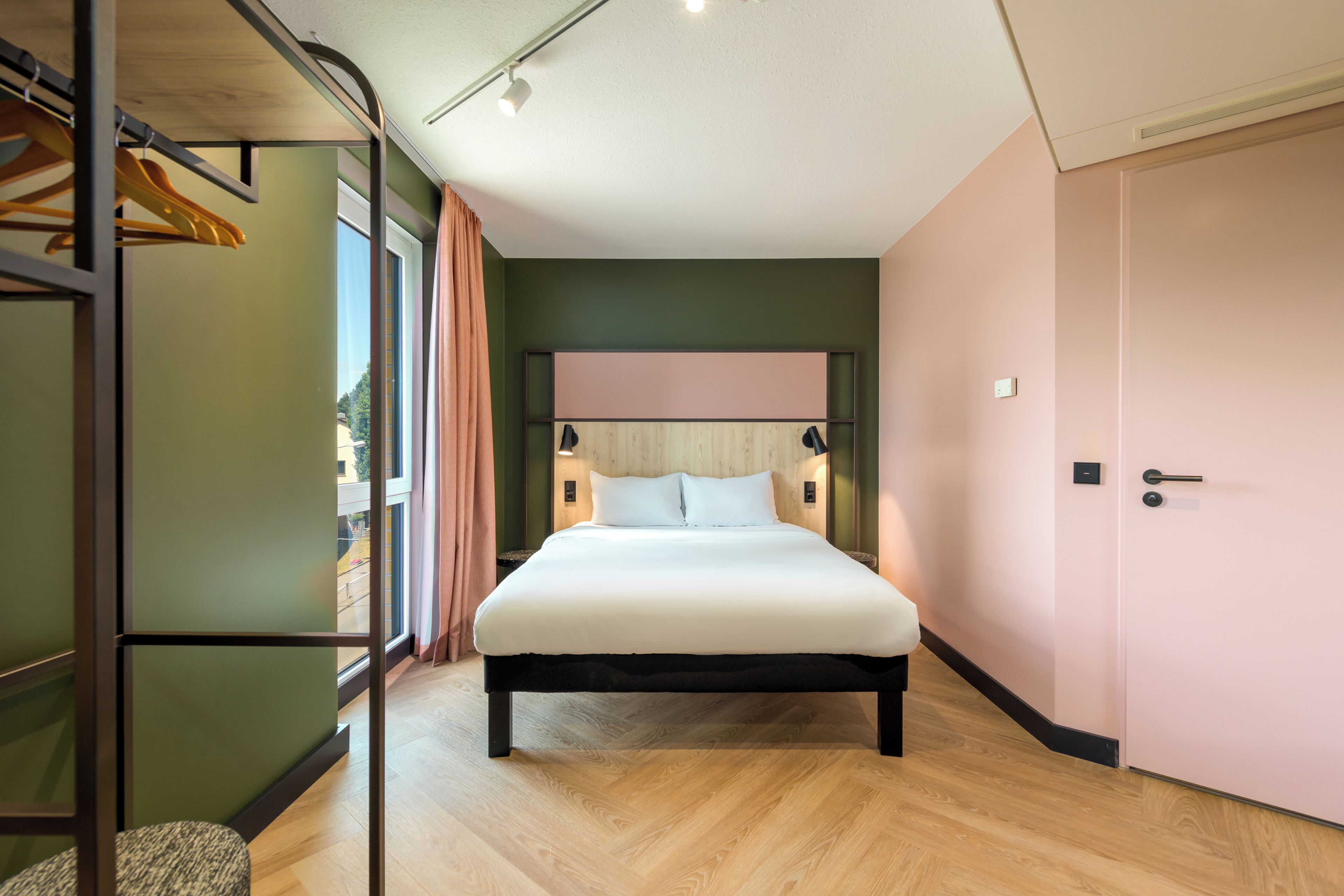 Une chambre moderne avec un lit, une armoire et une fenêtre avec des rideaux.