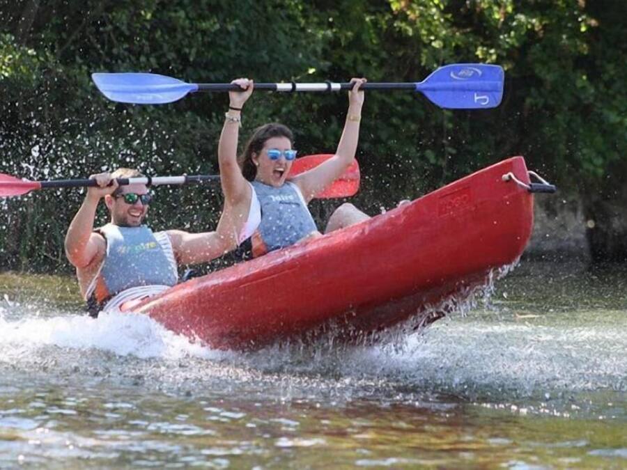 Due persone che fanno kayak in una canoa rossa su un fiume.