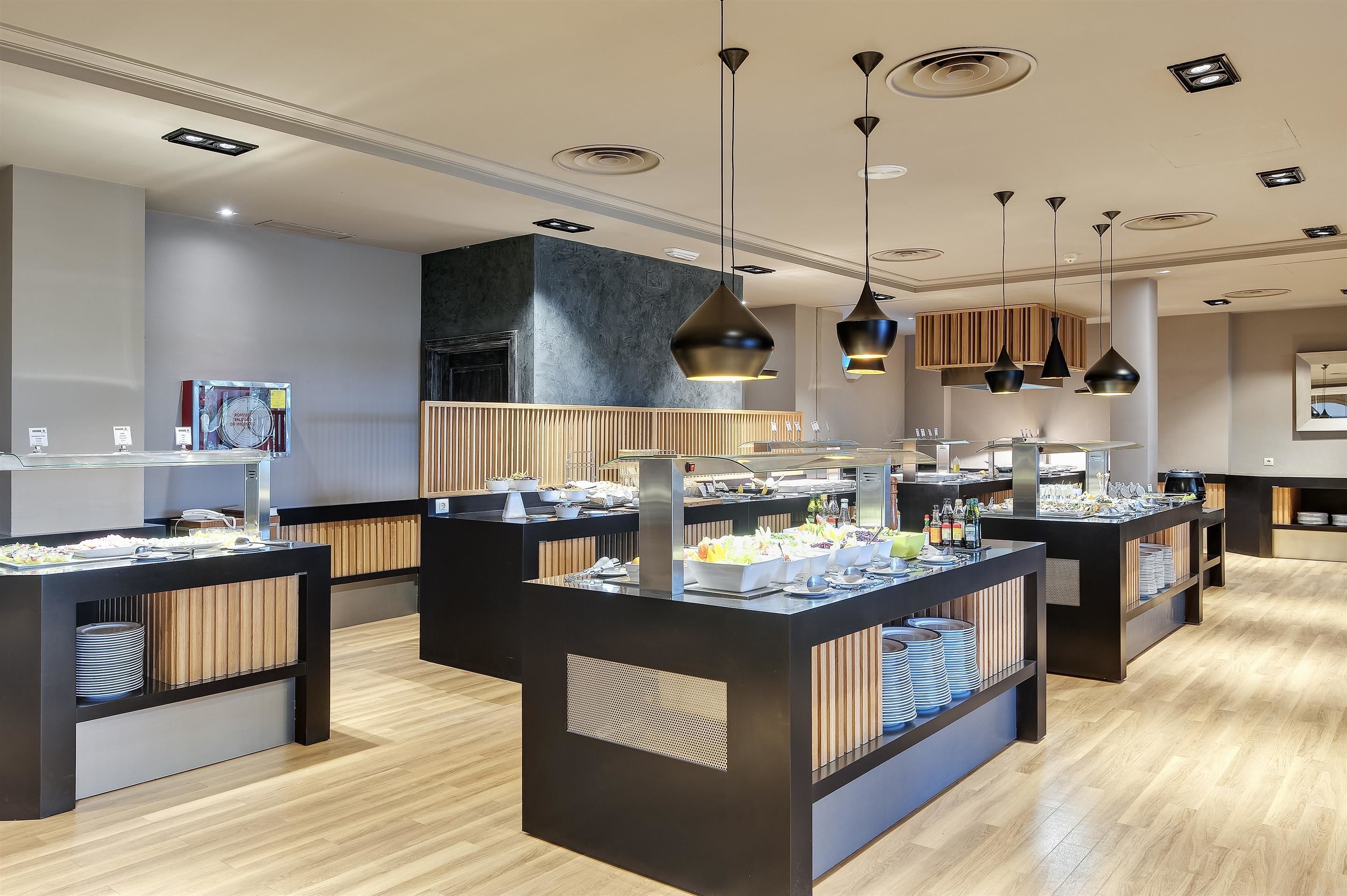 A modern buffet setup with multiple serving stations, each equipped with a variety of food items and utensils.