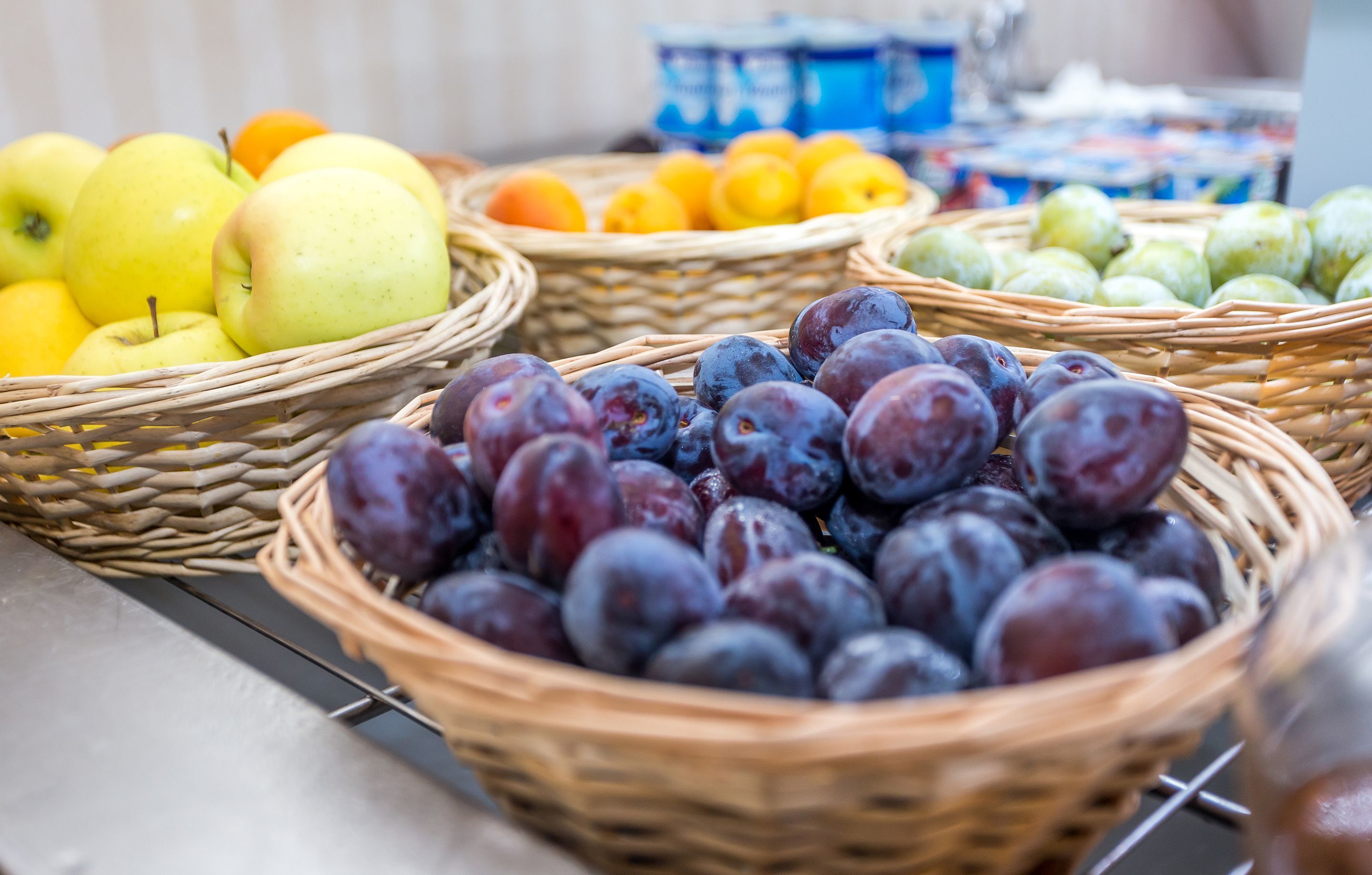A display of various fruits in wicker baskets.