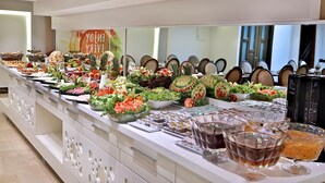 Monipuolinen buffet, jossa on tarjolla erilaisia ruokia ja juomia.