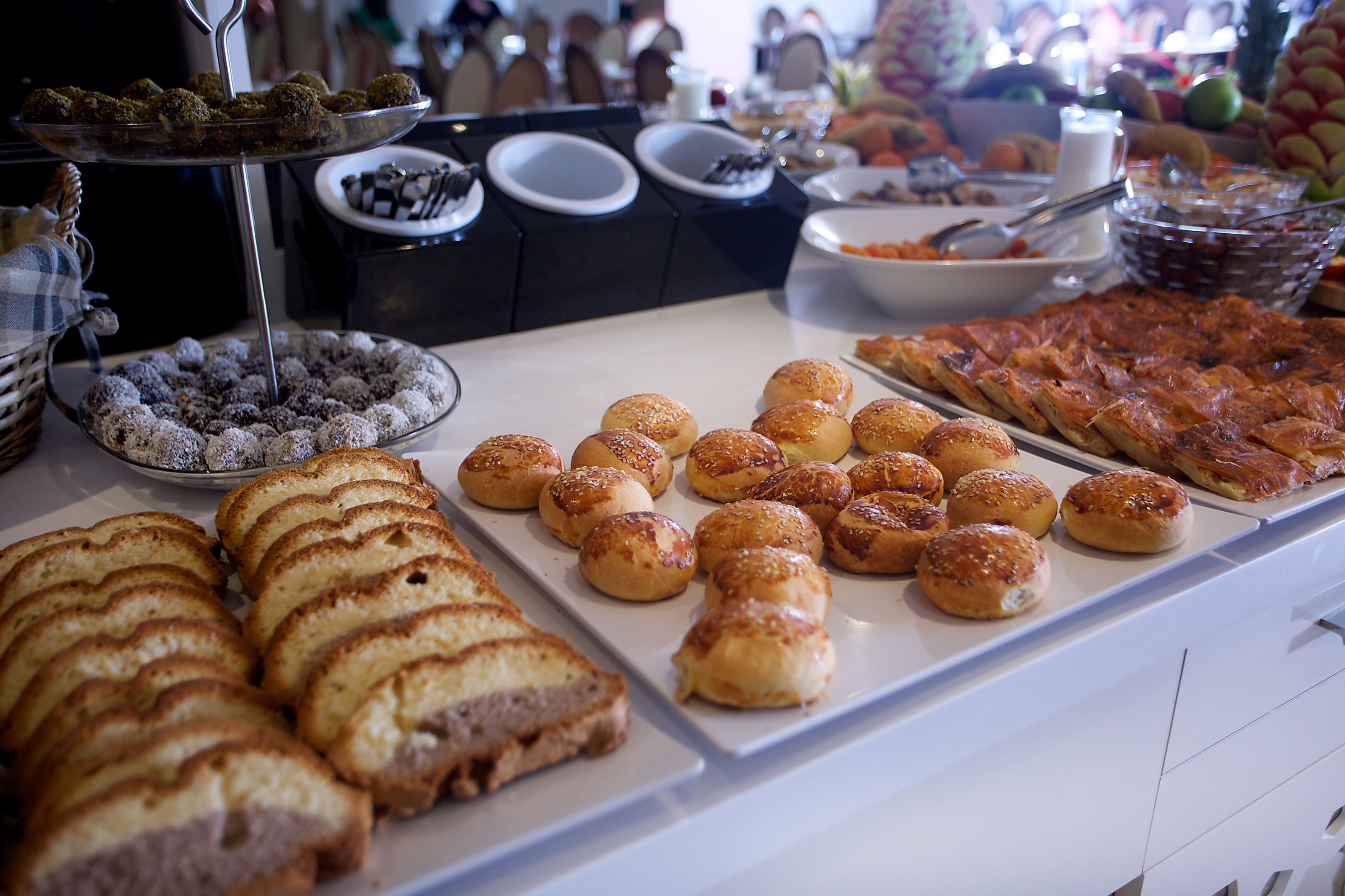A buffet with various food items including bread, pastries, and desserts.