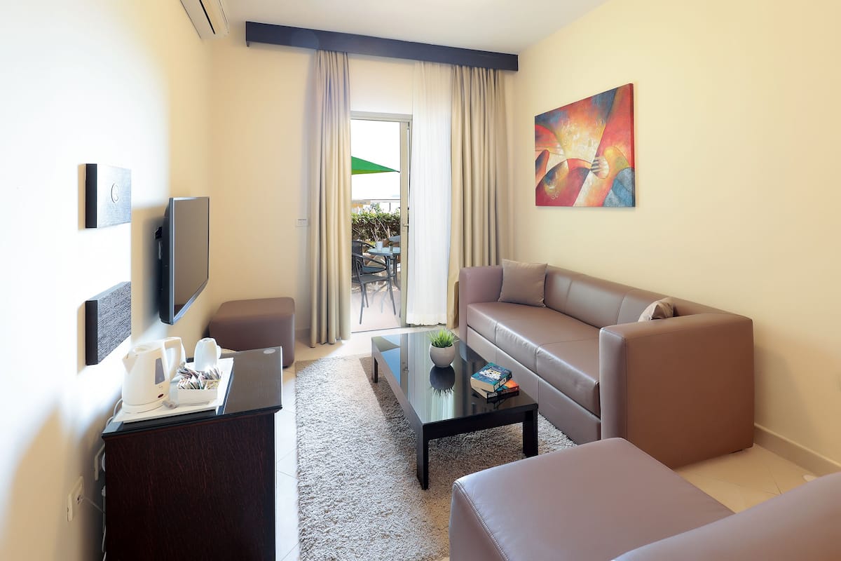 Un salón moderno con un sofá, una mesa de centro y un televisor montado en la pared.