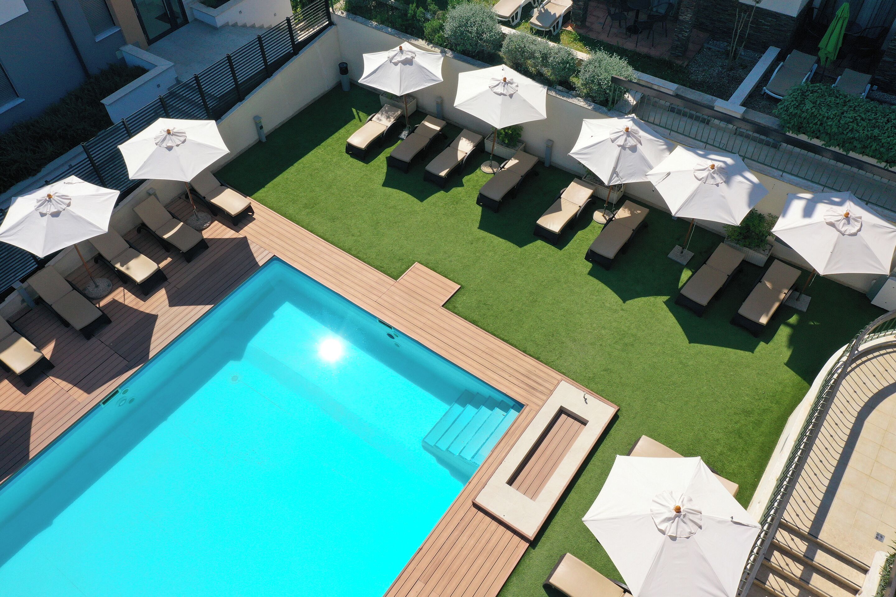 Et tagområde med swimmingpool, liggestole og parasoller.
