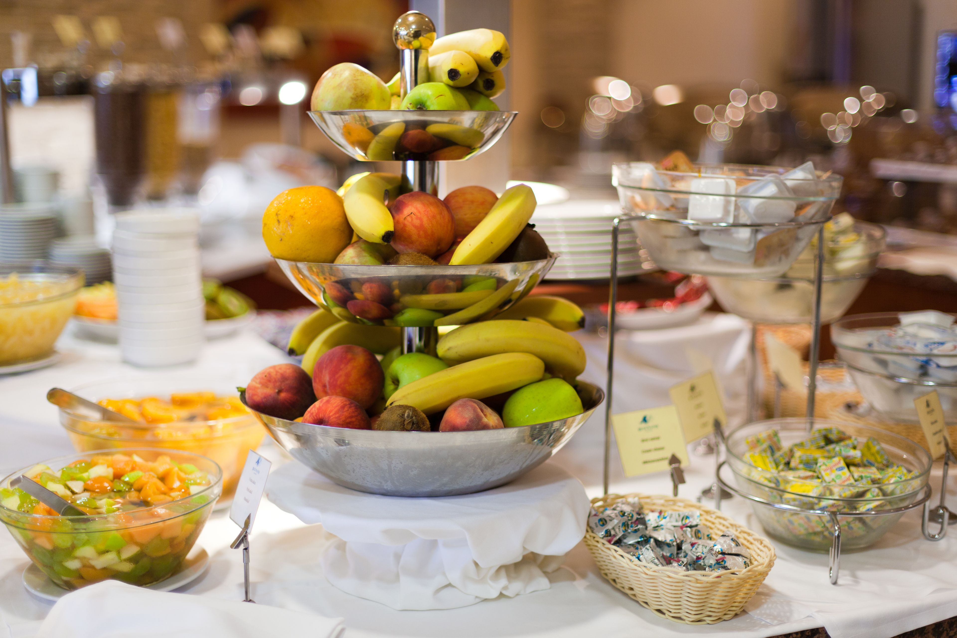 A buffet with various food items including fruits, vegetables, and desserts.