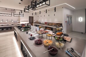 A modern kitchen with a long counter, various food items, and modern lighting fixtures. - Blue Waves Resort (Malinska-Dubasnica)