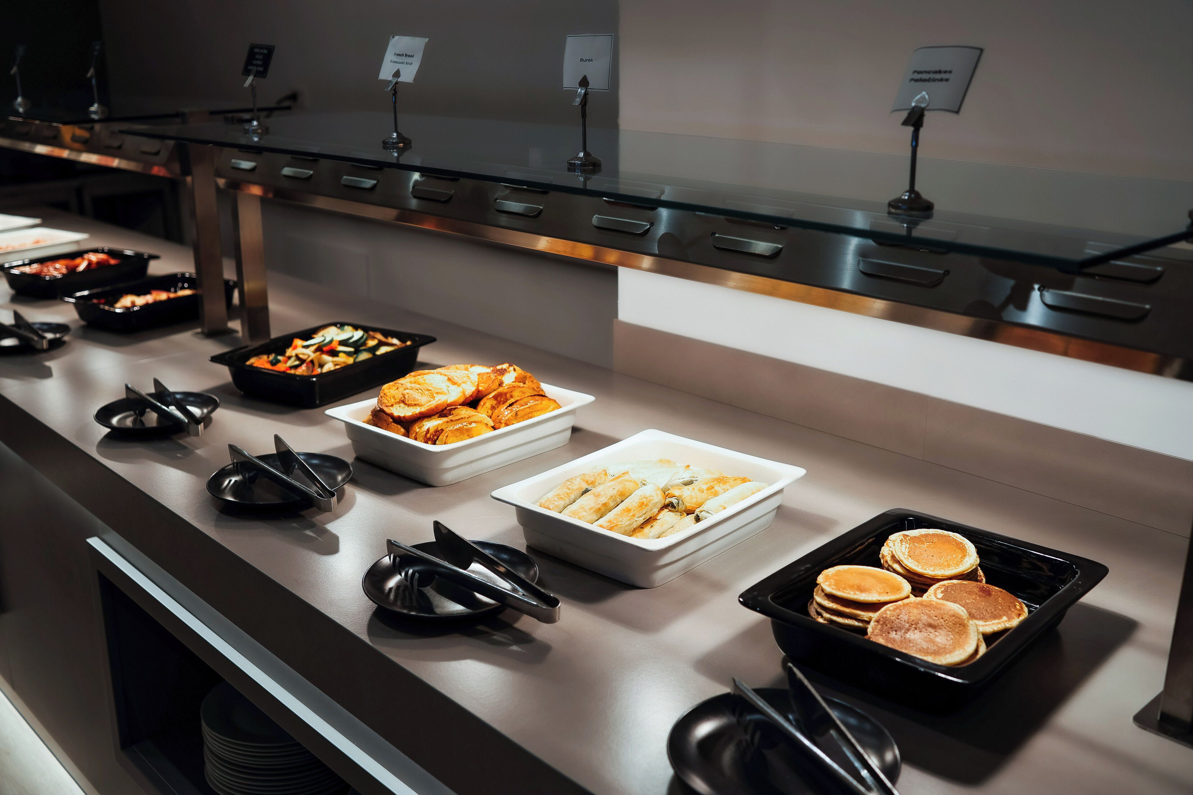 A buffet with various food items, including pancakes, salads, and other dishes.