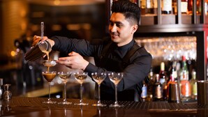 A bartender pouring a drink into a martini glass. - Hilton The Hague (The Hague)