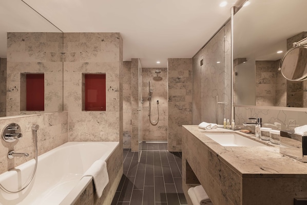 Un baño moderno con bañera, ducha y dos lavamanos.