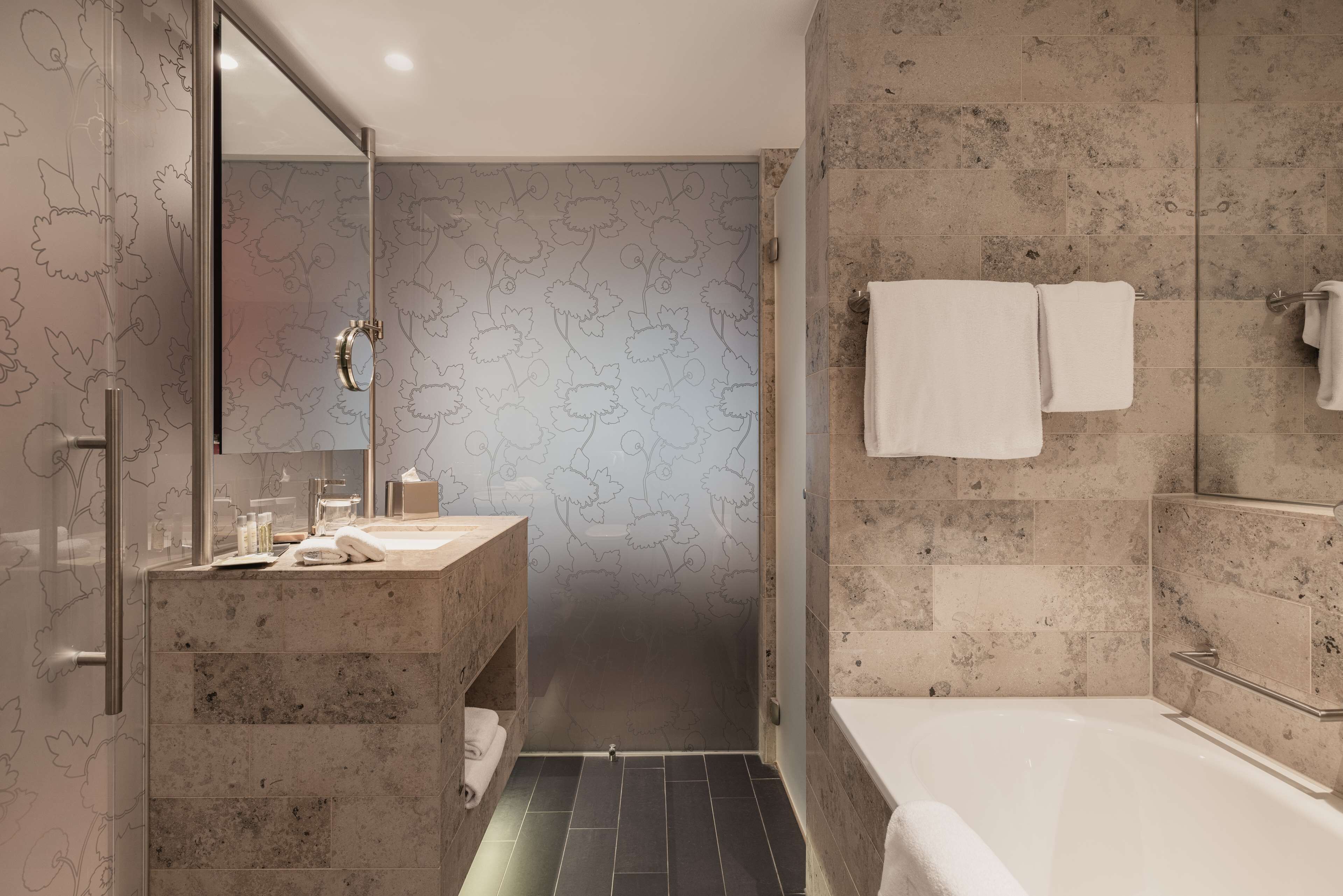 Ein modernes Badezimmer mit Dusche, Badewanne und Waschtisch mit Spiegel.