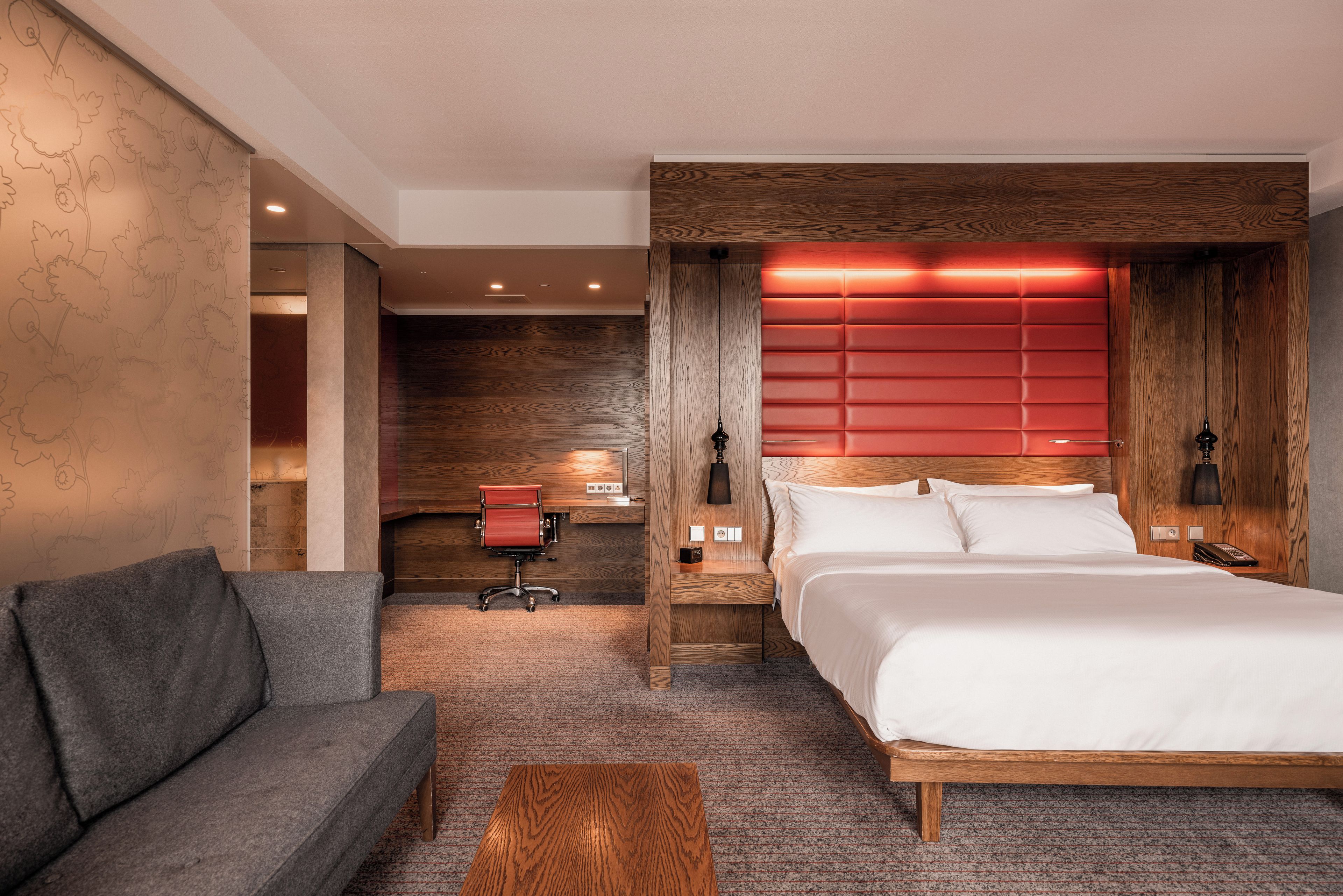 Une chambre d’hôtel avec un lit, un canapé, un bureau et une chaise.