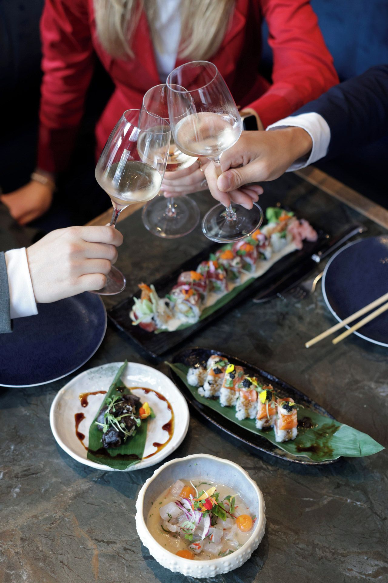 Een eettafel met sushi gerechten en een soepkom.