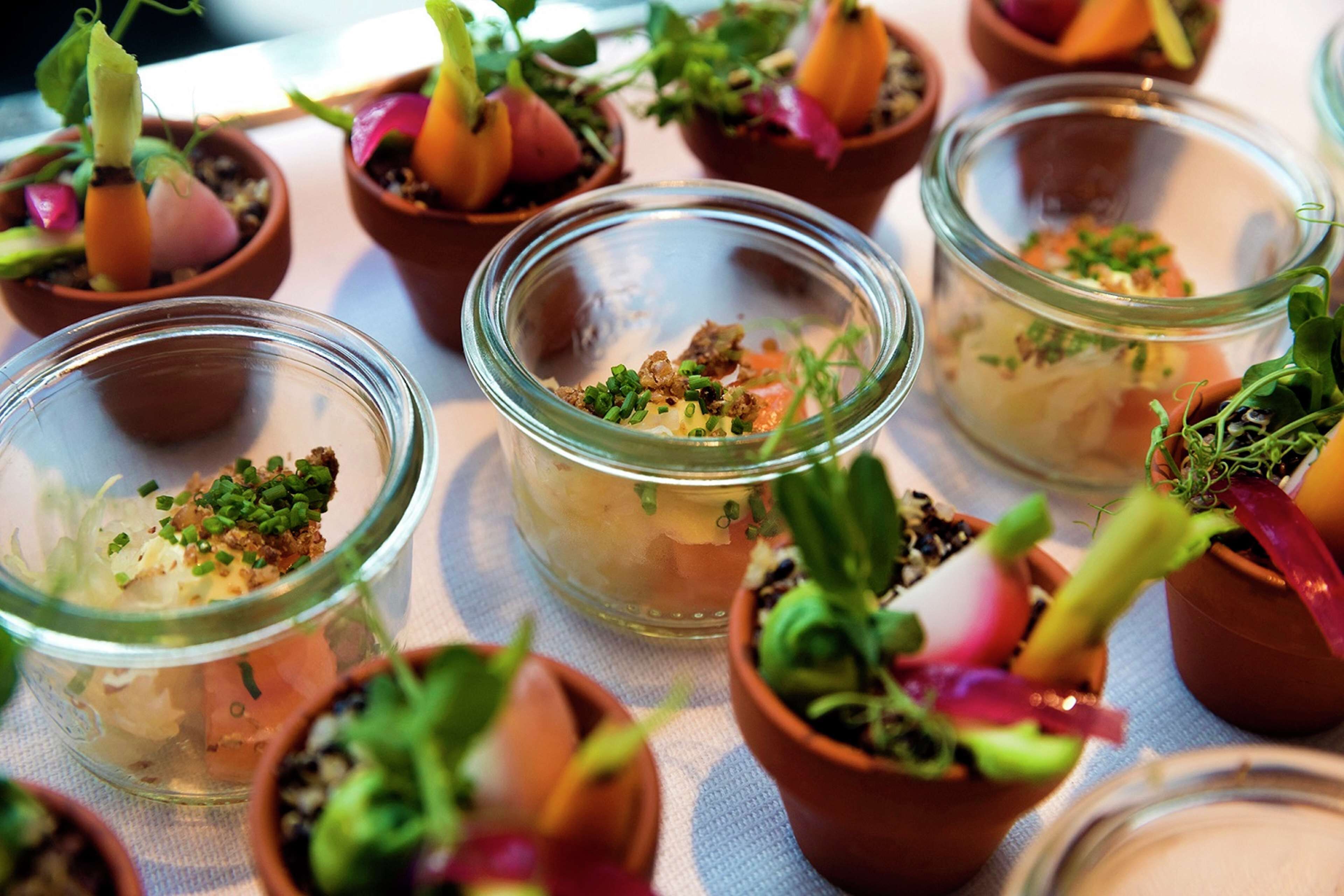 A table with various dishes and small potted plants.