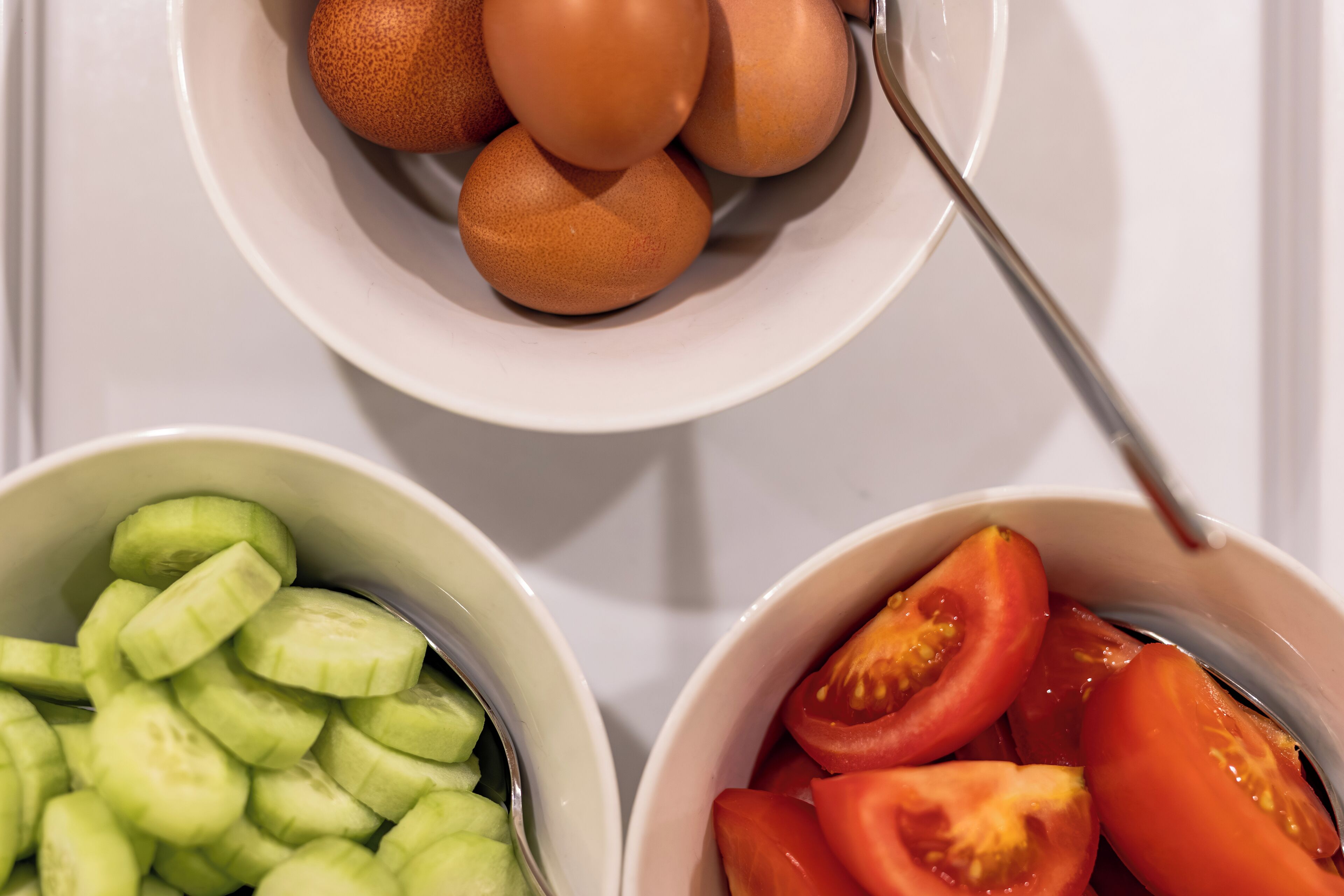 Due ciotole, una con fette di cetrioli e l'altra con fette di pomodori.