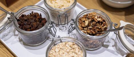 A tray with four glass jars containing different food items.
