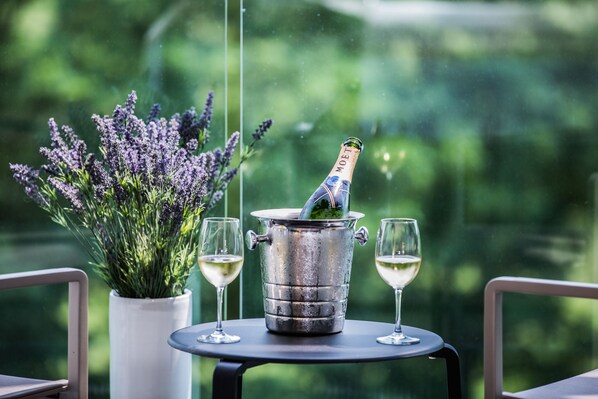 A bottle of Moët champagne in a metal bucket with two glasses of white wine on a table. - HSM Hotel San Martino (Garbagnate Monastero)