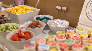 Buffet com diversos alimentos, incluindo frutas, legumes e pratos preparados.