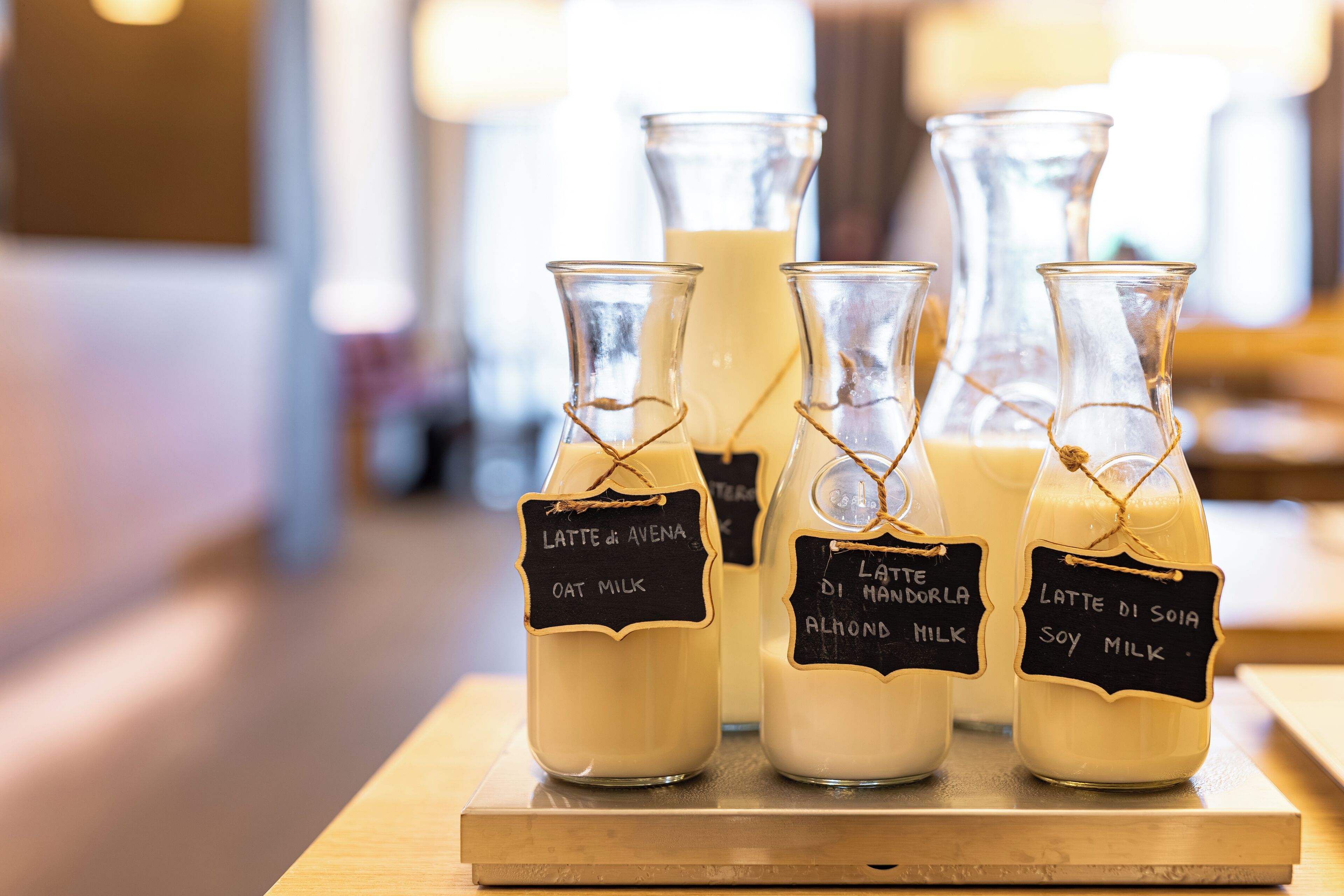 Cuatro botellas de vidrio con etiquetas sobre una superficie de madera.