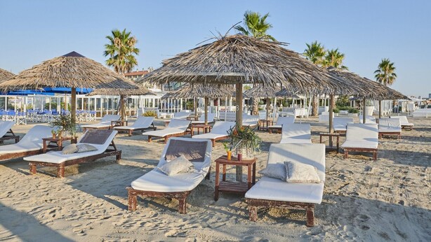 A beach with thatched umbrellas and lounge chairs. - Fantini Club Hotel  (Cervia)