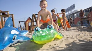 A beach scene with inflatable toys and a wooden structure in the background. - Fantini Club Hotel  (Cervia)