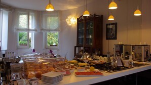 Una barra de buffet con diversos alimentos y un área de cocina con estufa y utensilios.
