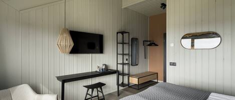 Un dormitorio moderno con cama, escritorio y silla.