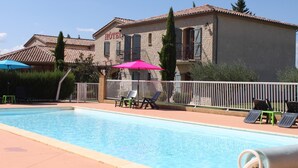 Un hotel con piscina, zona de estar al aire libre y patio cercado.