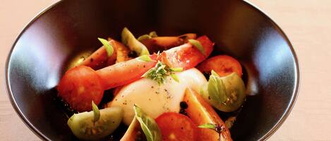 A bowl of food with tomatoes and basil.