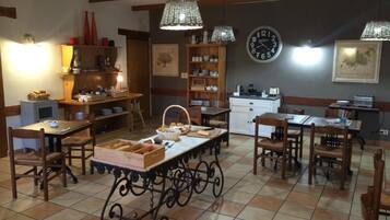 A cozy dining area with wooden furniture, a central table with bread baskets, and a clock on the wall.