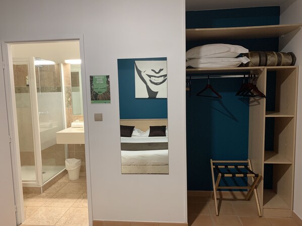 Una habitación con una cama, un sillón colgante y un armario con estantes.