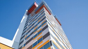 A modern high-rise building with multiple floors, large windows, and a mix of architectural styles. - Sky Hotel Apartments Tornet (Linkoping)