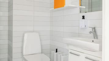 Et moderne badeværelse med toilet, vask og spejl.