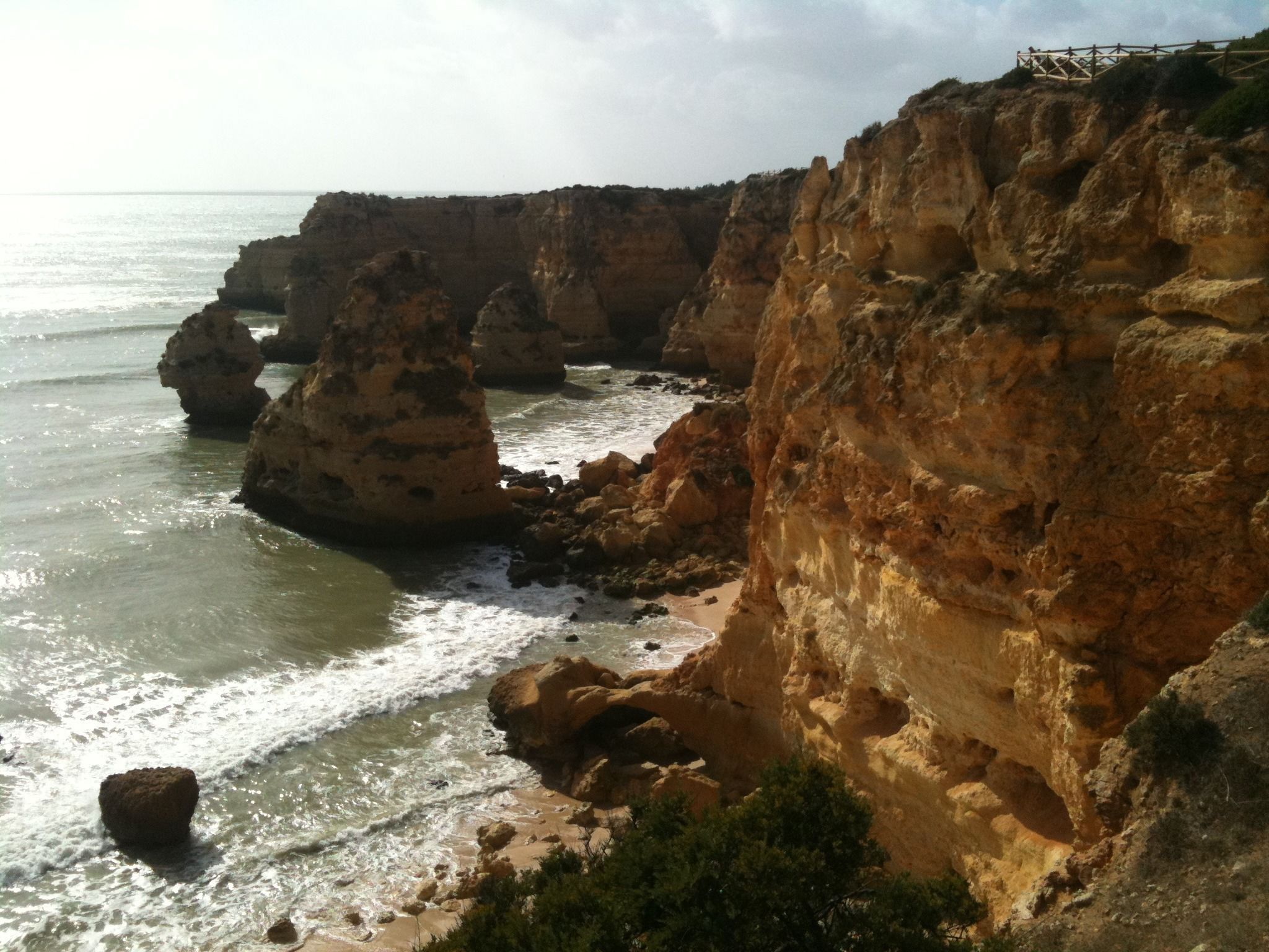 Un paysage côtier caractérisé par d’imposantes formations rocheuses et une plage.