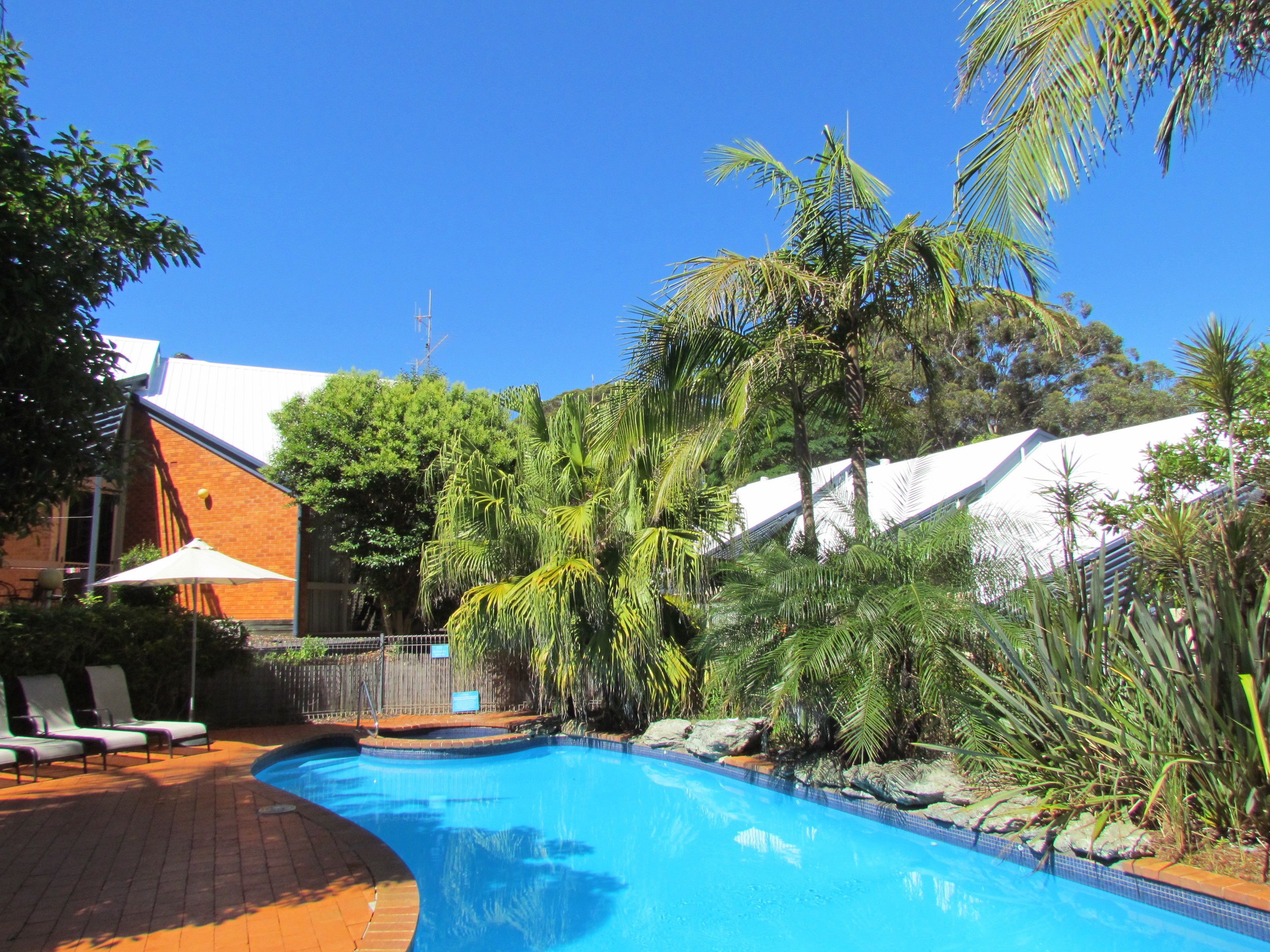 حمّام سباحة خارجي، مظلات على حمّام السباحة، مقاعد للتشمس