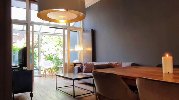 Un salon moderne avec une table à manger en bois, un canapé et un téléviseur.