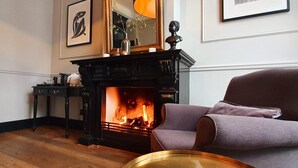 Une pièce avec une cheminée, un canapé et une table agrémentée d’objets décoratifs.