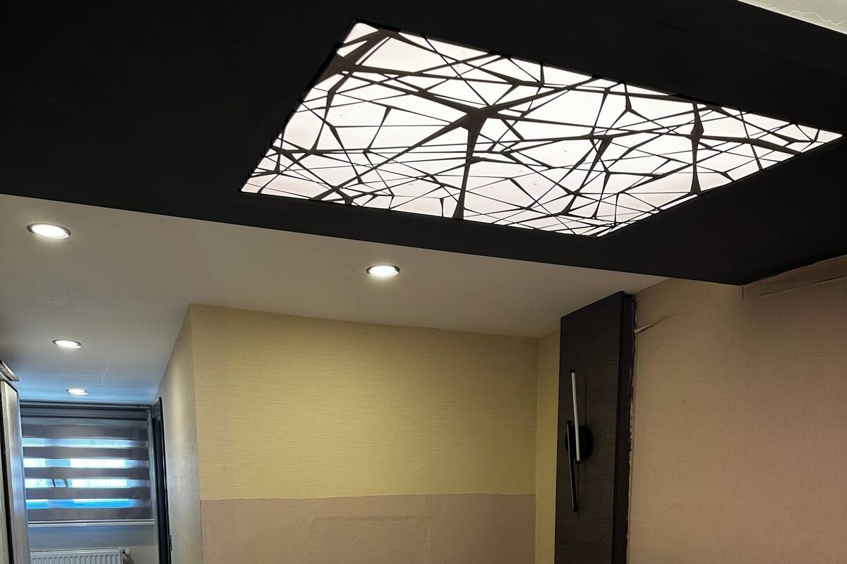 Una habitación de hotel moderna con una cama grande, un pequeño rincón de descanso y un diseño de techo original.