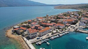 A coastal village with traditional architecture, a marina, and a clear view of the surrounding water and mountains. - Tamarix Residence (Posedarje)