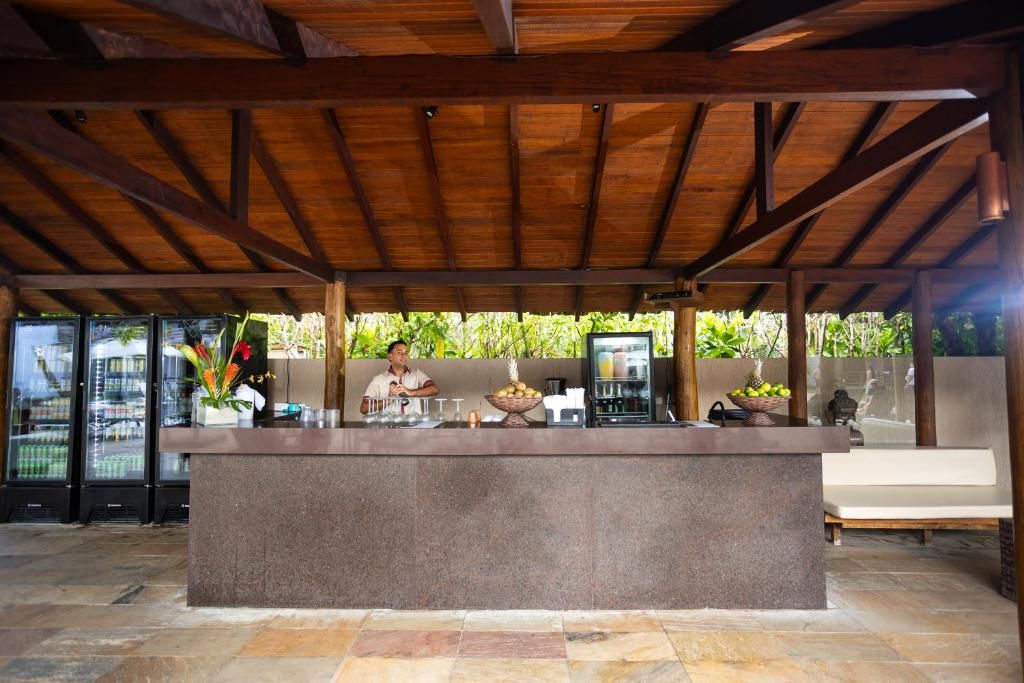 Uma área de recepção com balcão, assentos e vista para o verde.
