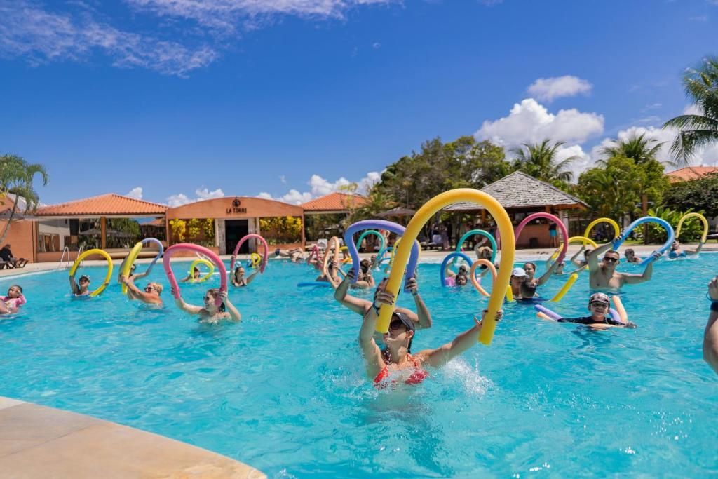 Piscina com pessoas usando argolas coloridas para exercício.
